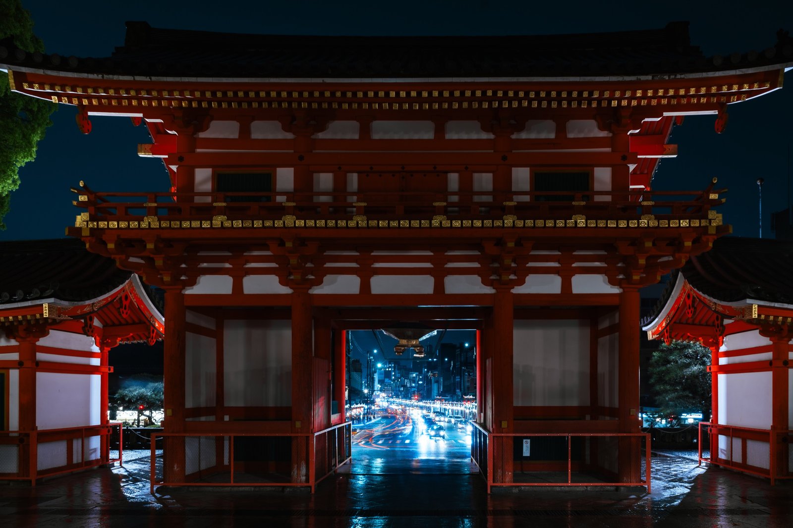 Illuminated gate at night with traffic visible beyond the opening