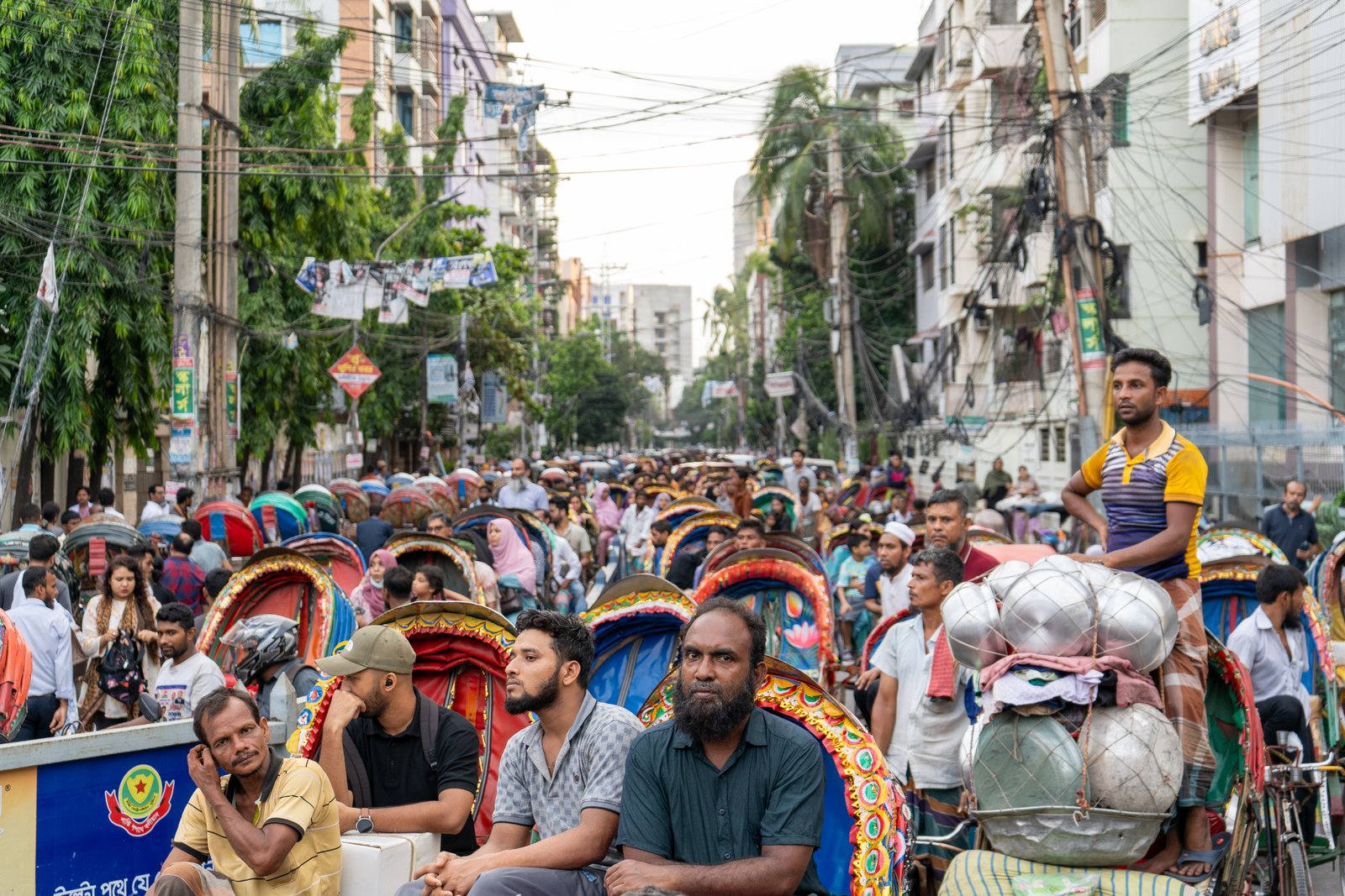 Dense crowd filling a Dhaka street blocked by protest activity