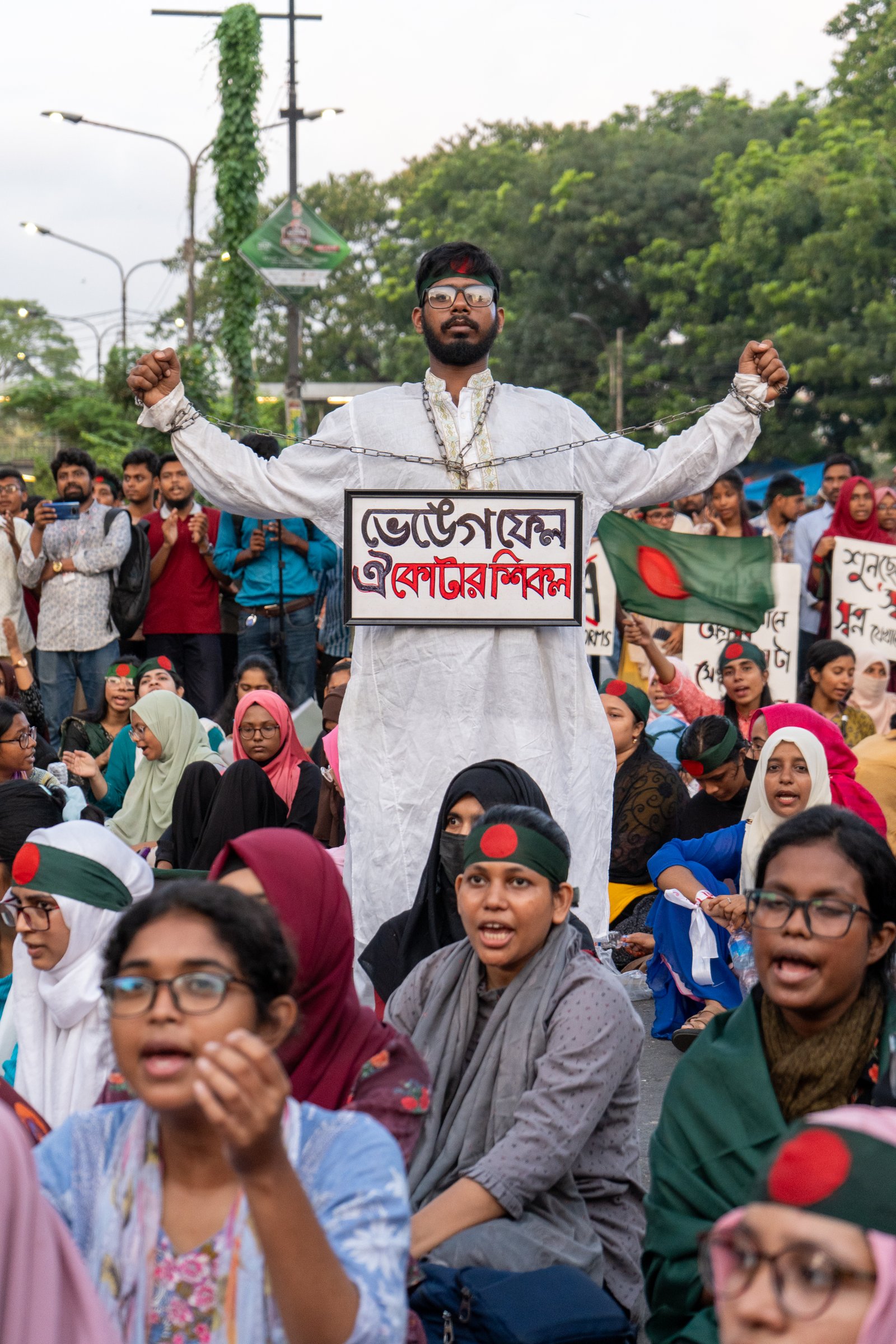 Protester with chained wrists raises both hands in a Dhaka march