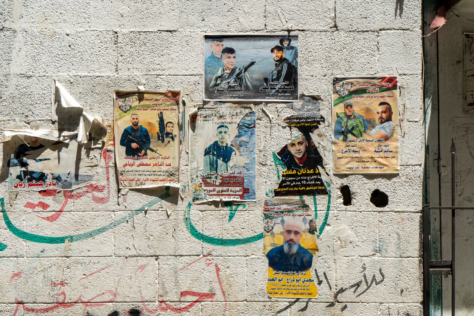 Wall covered in memorial posters for martyrs in a Nablus street