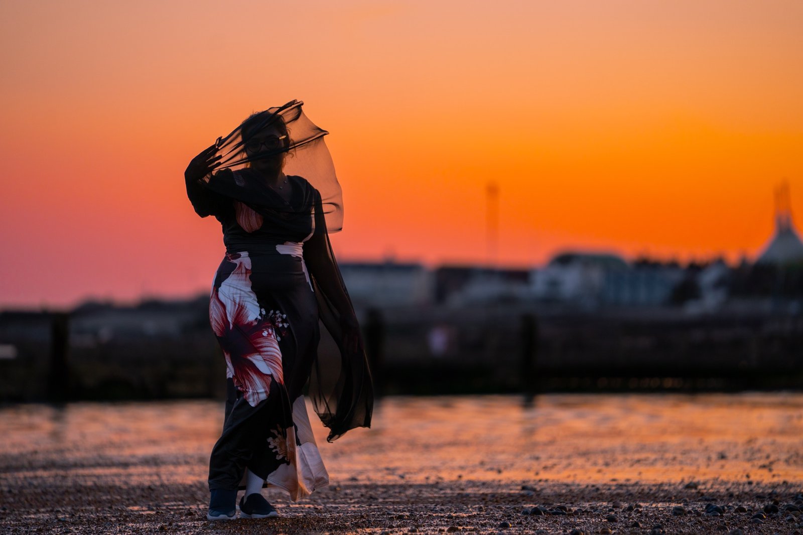 Figure moving through a beach at sunset in silhouette