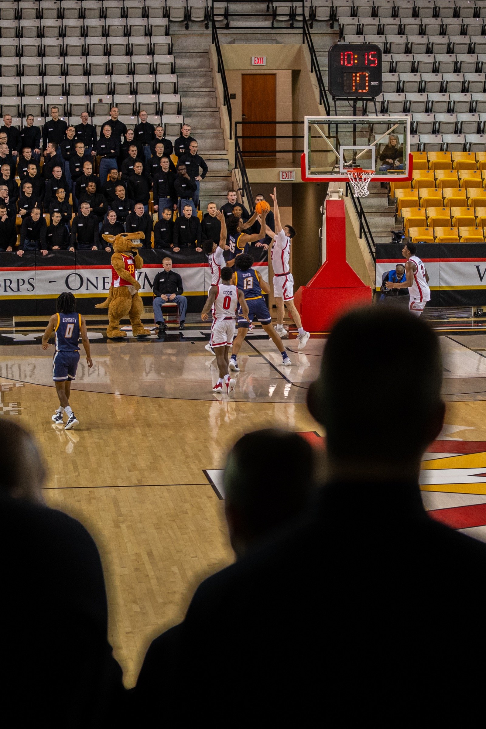Basketball players contesting a shot