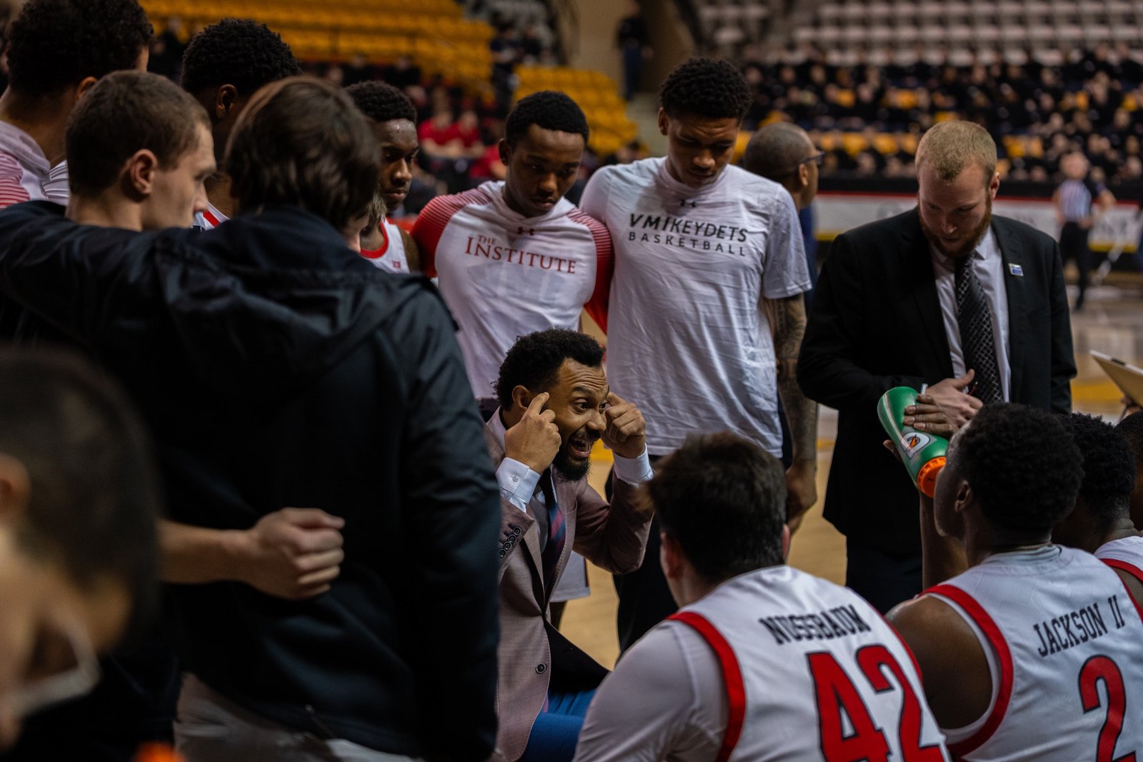 Coach speaking intensely to players in a timeout huddle