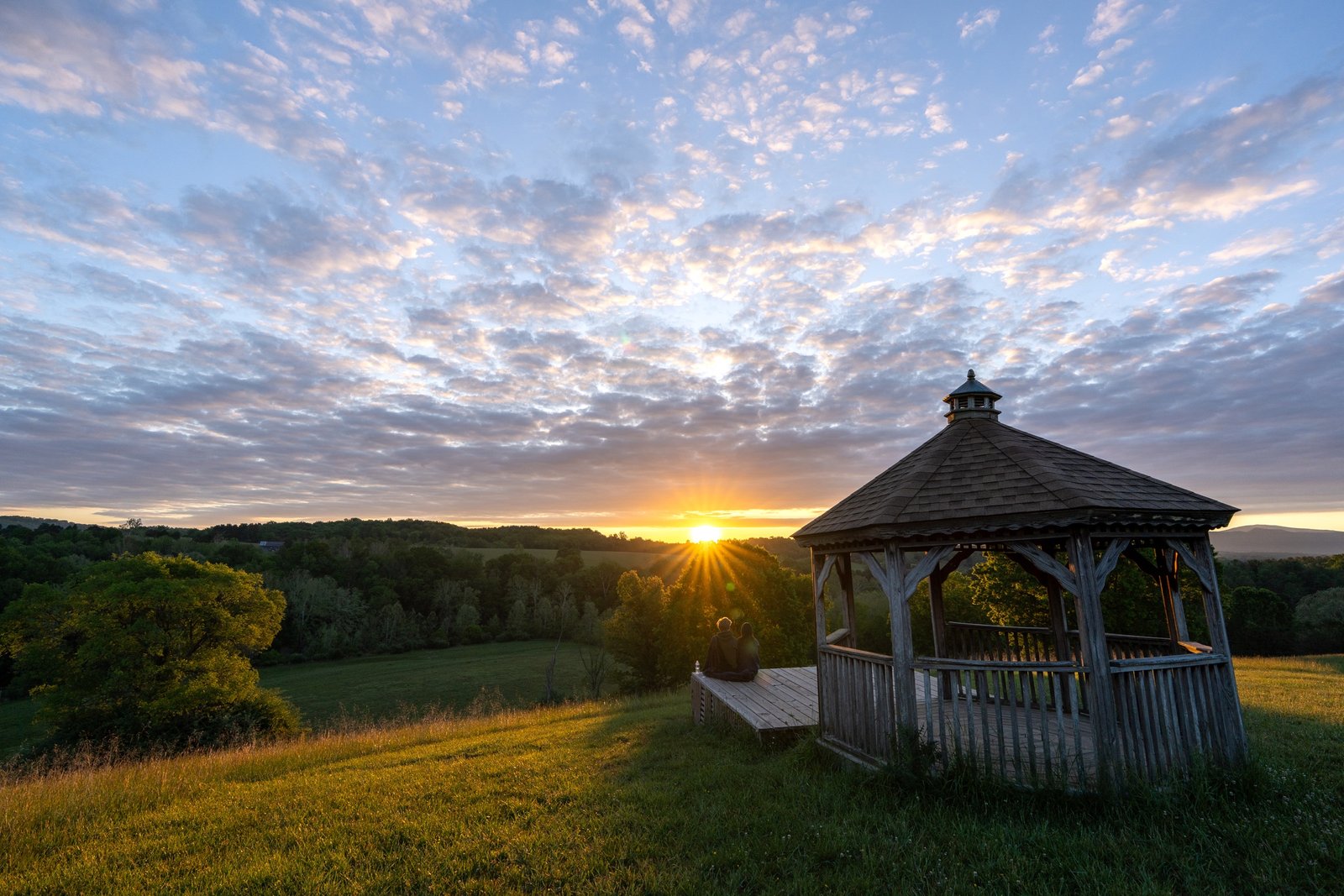 Sunrise over a gazebo and wooded valley